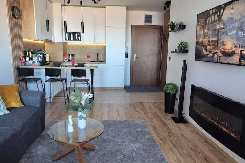 Un salon moderne avec un canapé, une table basse et une cheminée.