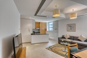 Relax in a spacious living area with a central island kitchen, comfortable seating, and a flat-screen TV.