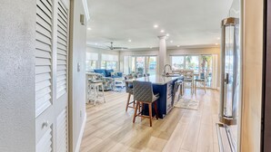 A spacious living area with a large island, a dining table, and a kitchen area. - 🌴New Updates🌞Awesome Bay Views🐬Land's End 4/201☀End Unit (Treasure Island)