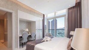 Et moderne hotelværelse med en stor seng, et skrivebord og udsigt over bybilledet.