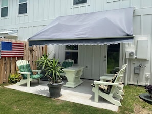 A patio with outdoor furniture, a covered area, and a white fence.