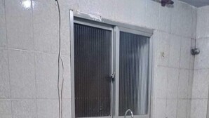 Una cocina compacta con microondas integrado, un lavamanos y una ventana sobre la encimera.