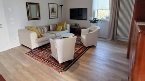 A modern living room with a sofa, armchairs, a coffee table, and a patterned rug. - Nuova Porta dei Musicisti (VERONA)