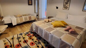 A hotel room with two beds, a colorful rug, and a painting on the wall. - Nuova Porta dei Musicisti (VERONA)