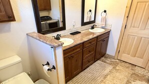 A bathroom with two sinks, a toilet, and a trash can. - Wharton Wilderness Ranch House (South Fork)