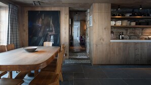 Una cocina moderna con armarios de madera, un comedor con una mesa grande y vistas a una sala de estar.