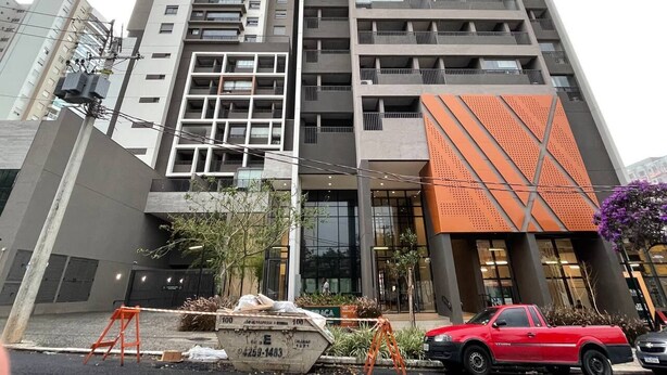 Un edificio de varios pisos con un diseño arquitectónico moderno, que cuenta con balcones y ventanas amplias.
