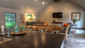 A spacious kitchen with a large island, dining area, and seating.