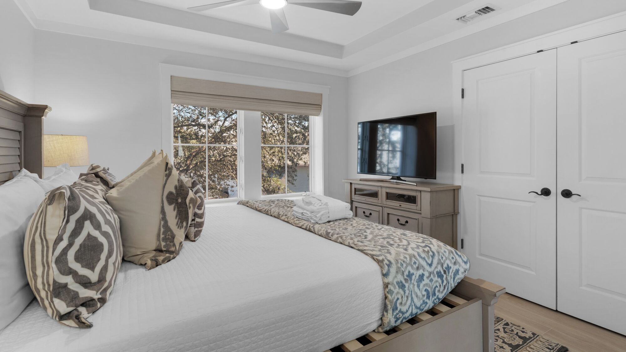 Un dormitorio con cama, televisión, ventana y armario.