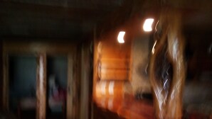 Um quarto com pouca luz, paredes de madeira e um espelho grande e ornamentado.