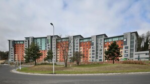 Un immeuble d’appartements moderne, doté de plusieurs étages, de grandes fenêtres et d’un toit plat.