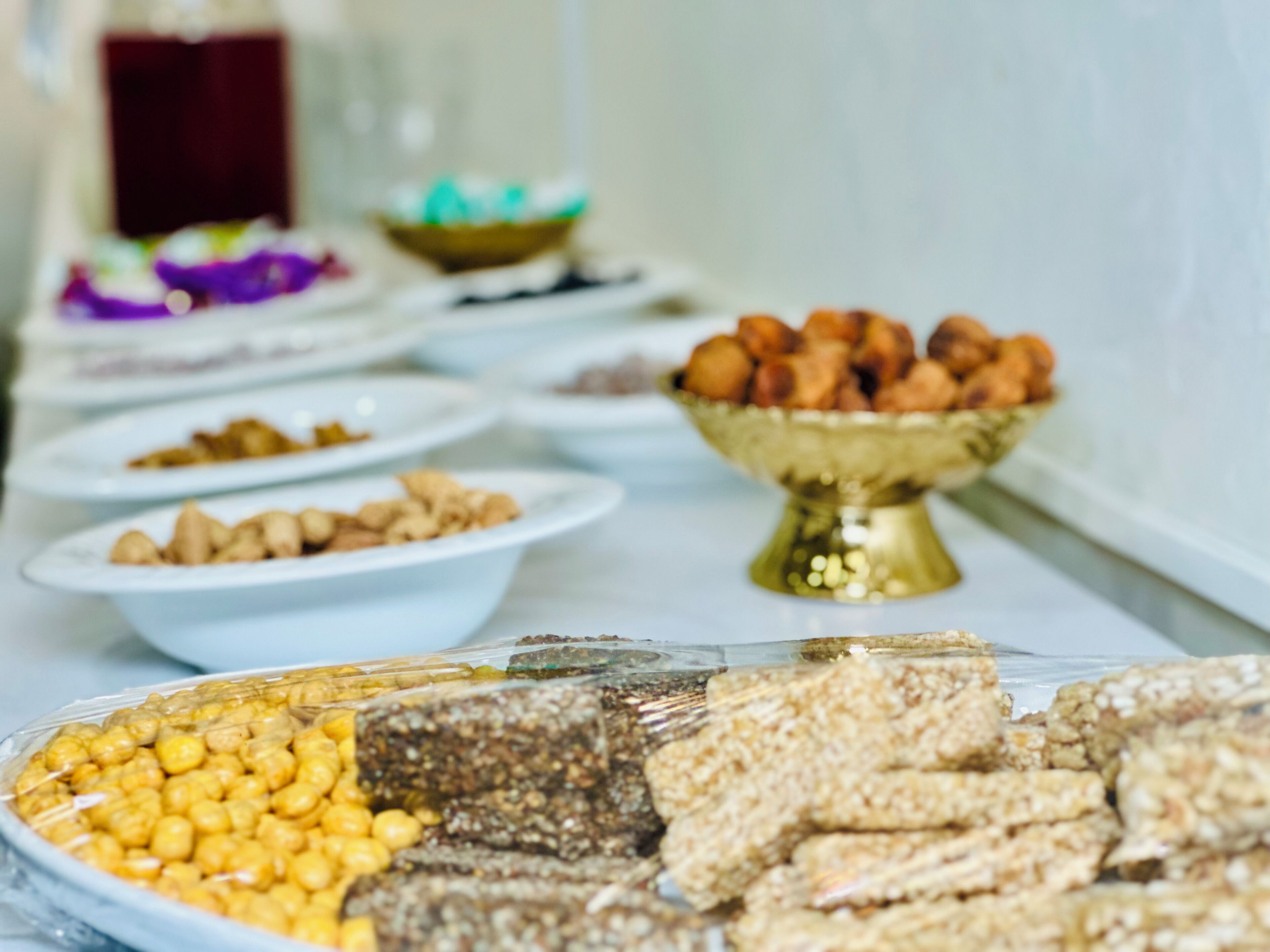 A buffet table with various food items including nuts, chickpeas, and granola bars.