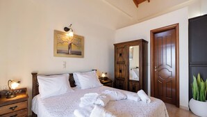 Ein Schlafzimmer mit einem großen Bett, einem Holzschrank und einem Gemälde an der Wand.