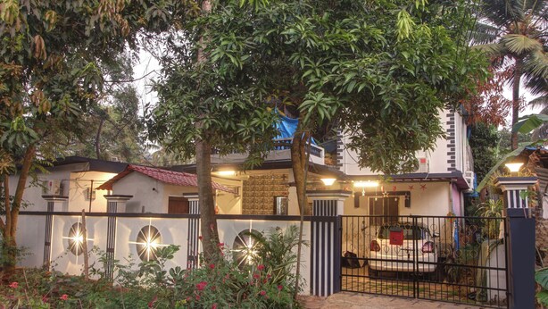 Zona residencial amurallada con un edificio blanco, cochera cubierta y entrada con portón.