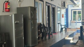 Una cocina con electrodomésticos de acero inoxidable, un extintor y una escalera que lleva a un espacio exterior.
