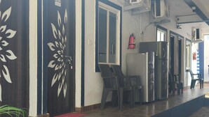 Un pasillo con una puerta de diseño, un extintor y un refrigerador.