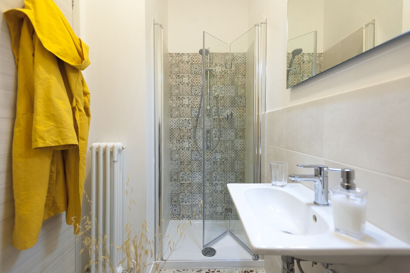 Ein Badezimmer mit Dusche, Waschbecken und Spiegel.