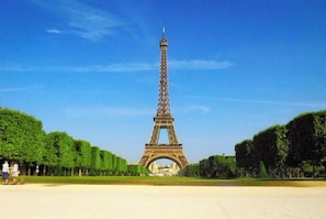 The Eiffel Tower with a clear sky, surrounded by neatly trimmed trees. - Charming Parisian loft for 2 to 4 people (Paris)