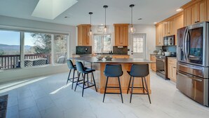 Una cocina moderna con una isla grande, armarios de madera y electrodomésticos de acero inoxidable.