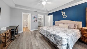 A bedroom with a bed, a desk, and a ceiling fan. - Charming Cozy  3-bedroom house with WiFi, fitness room in lovely Ocala (Ocala)
