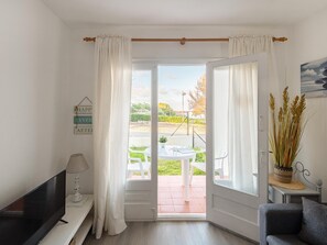 Relax in a serene space with a flat-screen TV, comfortable seating area, and access to an outdoor space.