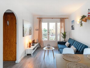 Relax in a stylish living space with a comfortable sofa, potted plant, and large window offering a view of the outdoors.