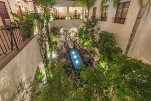 A courtyard with a central pool, surrounded by seating areas and lush greenery. - Pueblo Bonito Vantage Centro Histórico Mazatlán (Mazatlán)