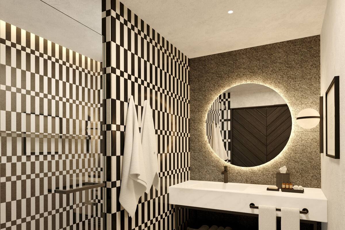 A modern bathroom with a checkered wall pattern, a round mirror, and a white sink.