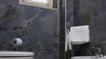 Un baño con dos lavamanos, un inodoro y una ventana con cortina.