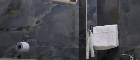 A bathroom with two sinks, a toilet, and a window with a curtain.