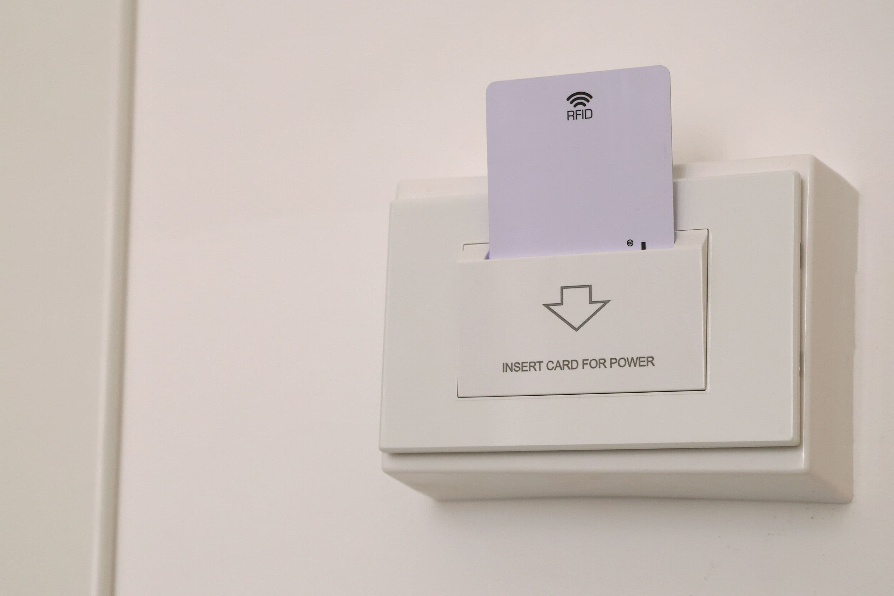 A white card reader with an RFID card inserted, labeled "INSERT CARD FOR POWER".
