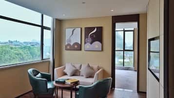 Una habitación moderna con un sofá, dos sillones, una mesita y una obra de arte en la pared.