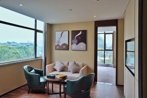 A modern room with a sofa, two armchairs, a small table, and artwork on the wall. - Li River Purejoy Hotel Guilin - Elephant Trunk Hill - Two Rivers and Four Lakes Branch (Guilin)