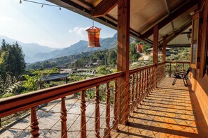 A wooden balcony with a tiled floor, a metal railing, and a hanging lantern. - Hmong farmstay (Ta Van)