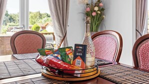 Une table à manger avec une bouteille de Prosecco, un paquet de chips Walkers et un sachet de chips Walkers au sel et au vinaigre.