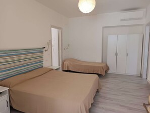 A bedroom with two beds, a wardrobe, and a small table. - Forio d 'Ischia- cozy apartment with  2 bedrooms, bathrooms and private terrace. (Forio)