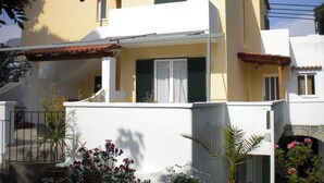 A two-story house with a balcony, a small porch, and a tiled roof. - The Vineyard (Forio)