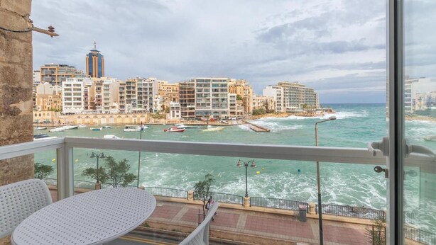 A balcony with a view of a coastal cityscape, including buildings and the sea. - Seafront Designer Bliss in Central St Julian's (St. Julian's)