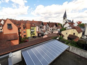A residential area with colorful houses, a church with a steeple, and a solar panel on a rooftop. - Hotel-Pension zum Hirsch (Hattersheim)