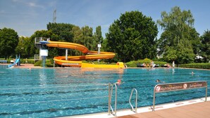 Una piscina con tobogán y un cartel que indica prohibido bañarse.