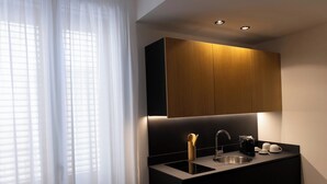 Cocina moderna con encimera negra, pileta de acero inoxidable y muebles de madera.