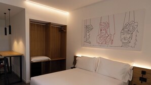 A modern hotel room with a bed, bedside table, and a wooden wardrobe. - Deluxe Triple Studio with Terrace (Bagheria)