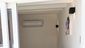 Een kleine, moderne kamer met een houten tafel, een zwarte kruk en een glazen scheidingswand.