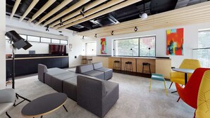 Un interior moderno con un sofá modular, una zona de bar y una mesa de comedor.