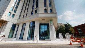 Un edificio moderno con grandes ventanales y una entrada destacada.