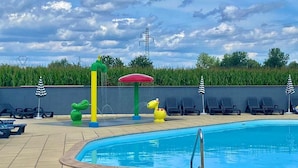 A swimming pool with a tiled deck, lounge chairs, and decorative animal figures. - Smart Home Paris mit Terrasse, Europapark, Rulantica 15min (Boofzheim)