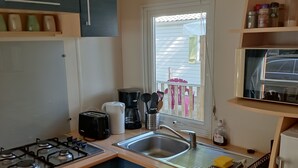 A compact kitchen with a gas stove, a sink, and a microwave. - Smart Home Paris mit Terrasse, Europapark, Rulantica 15min (Boofzheim)
