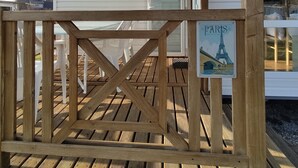 A wooden deck with a sign reading "PARS" and a view of a white building with a garage door labeled "IRM". - Smart Home Paris mit Terrasse, Europapark, Rulantica 15min (Boofzheim)