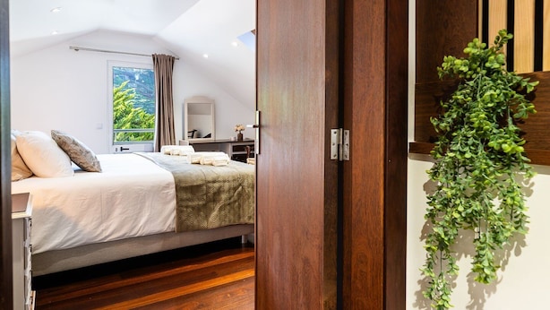 Un dormitorio moderno con cama, mesita de noche y vistas a zonas verdes.