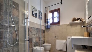 Ein Badezimmer mit Dusche, Toilette, Bidet und Waschbecken.